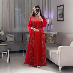 Détail de la broderie florale argentée et des paillettes sur une robe de soirée rouge