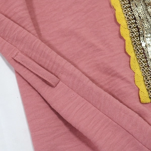 Close-up of pink jalabiya dress with gold sequins and embroidery detail