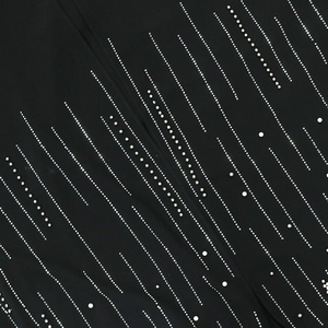 Close-up of black fabric with vertical rows of sparkling rhinestones and white pearls