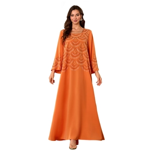Détail de l'abaya musulmane orange vif avec motifs de paillettes élégants sur les manches