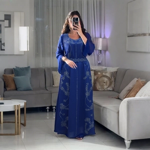 Broderie florale dorée détaillée sur une robe de soirée bleu marine à manches longues