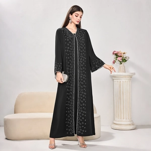 Macro detail of silver geometric embroidery and sequins on long black women's abaya