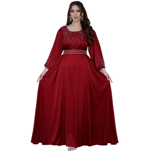 Détail d'une robe en satin rouge avec broderies de perles argentées à la taille et aux poignets