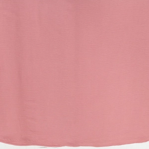 Close-up of pink pleated jalabiya dress fabric with fine stitched hem and soft texture