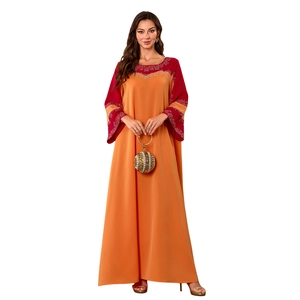 Détail de la robe caftan orange avec poignets en patchwork rouge et strass brillants