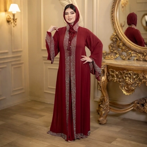 Detail of burgundy abaya set with sequin trim and tassels on a luxury background