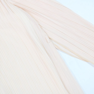 Détail rapproché de la texture plissée fine et couture sur une robe de soirée élégante