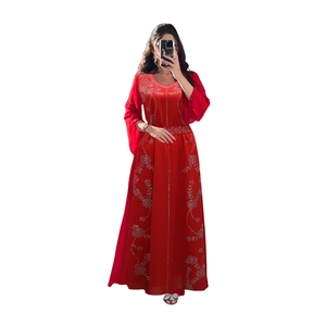 Détail de la broderie florale argentée sur la robe de soirée rouge en mousseline