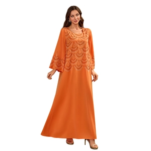 Détail de la broderie complexe sur une robe longue orange vif à coupe ample et fluide