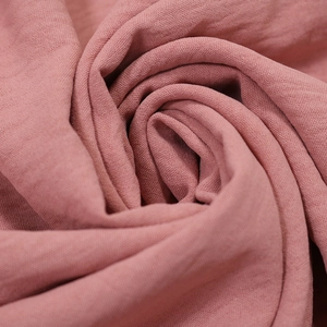 Close-up of dusty rose fabric texture with fine pleats and sequin lace detailing