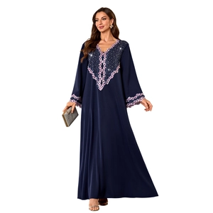 Detail of V-neckline featuring pink floral embroidery and rhinestones on a navy kaftan dress