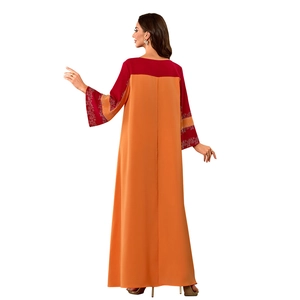 Détail de robe caftan orange et rouge avec imprimés floraux aux manches et au dos