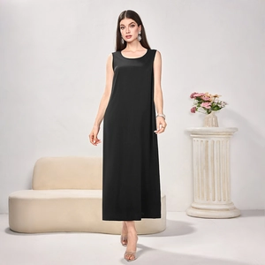 Detail of elegant black sleeveless maxi dress with silky satin texture and draped hem