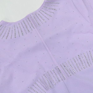 Detail of silver rhinestones on light purple dress fabric with elegant sparkling patterns