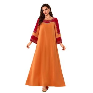 Détail d'une robe maxi bohème à manches longues contrastées avec broderies florales