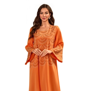 Détail de robe musulmane orange avec perles blanches délicates et manches évasées