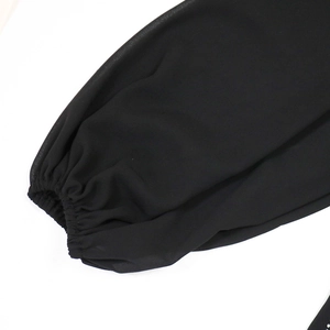 Close-up of elegant black chiffon lantern sleeves with elastic cuffs on a long evening gown