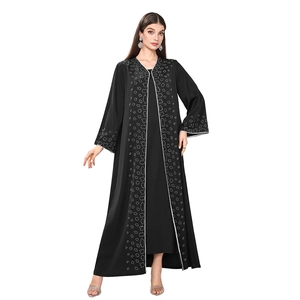 Detail of black abaya with silver dotted patterns and white piping on front and sleeves