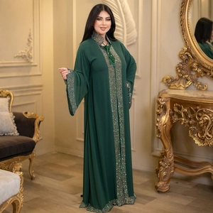 Detailed view of the luxury rhinestone border and beadwork on a green abaya robe