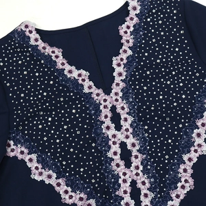 Detail of V-neckline with floral embroidery and silver rhinestones on navy blue robe