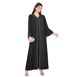 Close-up of sparkling silver rhinestones on a stylish black long-sleeve loose dress