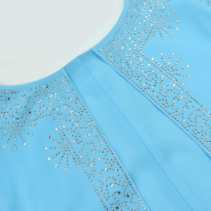 Detail of sky blue chiffon fabric with silver rhinestone star patterns and texture