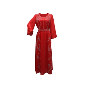 Détail de broderie florale argentée sur la manche et le corsage de la robe de soirée rouge