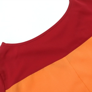 Détail de l'encolure ronde et de l'épaule d'une robe bicolore rouge et orange