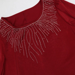 Détail macro de la robe de soirée bordeaux avec strass sur l'encolure ronde