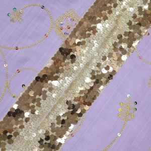 Close-up of purple fabric with gold sequins and embroidery for ethnic robes