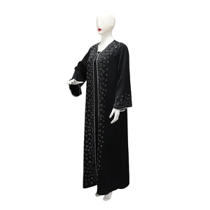 Detail of black long-sleeved Abaya with white dot pattern on collar and cuffs