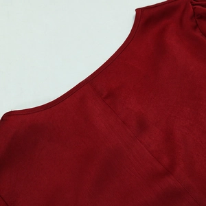 Détail de la robe de soirée bordeaux avec épaules plissées et coutures de précision