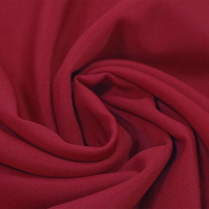 Macro detail of wine red V-neck dress fabric showing soft texture and fine drape
