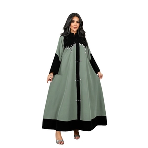 Detailed view of rhinestone beads and velvet patchwork on a green long sleeve abaya dress