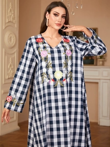 Close-up of intricate floral embroidery on the V-neckline of a blue gingham dress