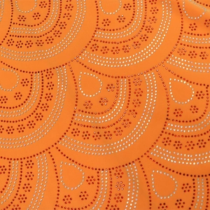 Détail macro de motifs en strass en éventail sur le tissu orange de la robe musulmane