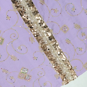 Detail of purple fabric with gold sequins and intricate ethnic floral embroidery patterns
