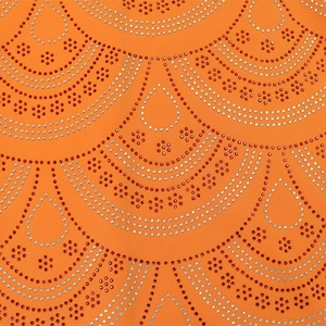 Détail du tissu orange avec motifs floraux complexes en strass rouges et argentés