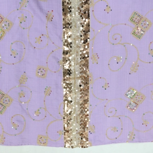 Detailed view of lavender fabric with intricate gold embroidery and sequin embellishments