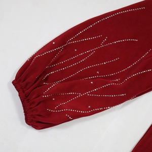 Gros plan du poignet en velours rouge avec motifs de strass argentés étincelants