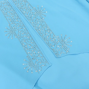 Macro view of light blue chiffon fabric featuring sparkling silver rhinestone star patterns