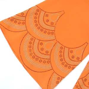 Détail de strass luxueux posés à chaud sur le tissu en mousseline orange
