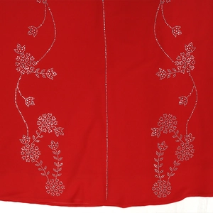 Détail du tissu rouge avec motifs floraux complexes en strass argentés et broderies de luxe