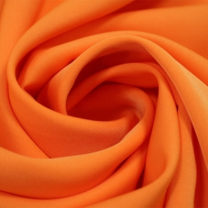 Macro détaillée du tissu mousseline orange vif montrant la texture fine et le drapé