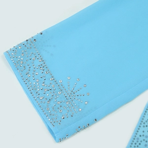 Detailed close-up of blue chiffon sleeve with intricate silver rhinestone edge embellishments