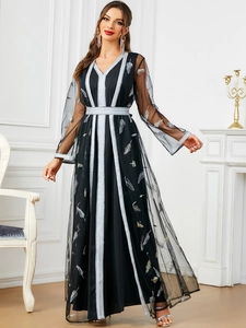 Close-up of elegant feather embroidery on a black mesh dress with silver trimming details