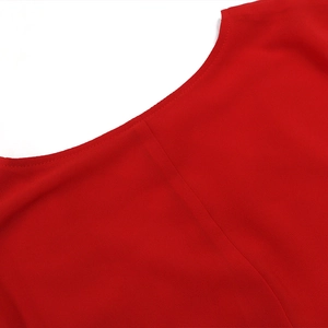 Détail d'une encolure ronde rouge avec coutures fines et texture en mousseline