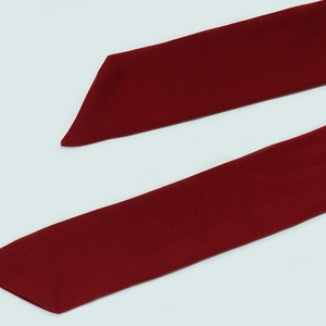 Gros plan détaillé de la ceinture en tricot bordeaux avec une texture fine et bout biais