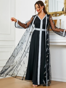 Detail of elegant black two-piece dress featuring silver lace embroidery and a sheer mesh layer