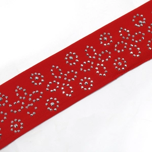 Détail de la ceinture en tissu rouge avec motifs de fleurs en strass étincelants et cristaux